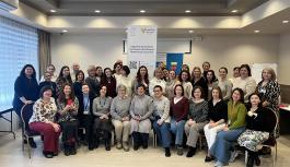 Group photo of over 40 participants of the Self-Support Leaders Conference in Kyiv, including self-support group leaders, psychologists, and community workers, standing and sitting together indoors in front of project banners.