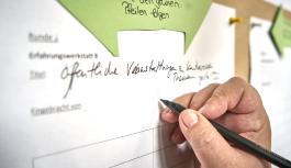 Anmeldung f&uuml;r den Workshop - im Bild von Hand, hier online