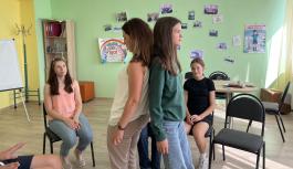 Zwei Sch&uuml;lerinnen stehen R&uuml;cken an R&uuml;cken und st&uuml;tzen sich gegenseitig w&auml;hrend einer Einheit des "Peaceful School Project"