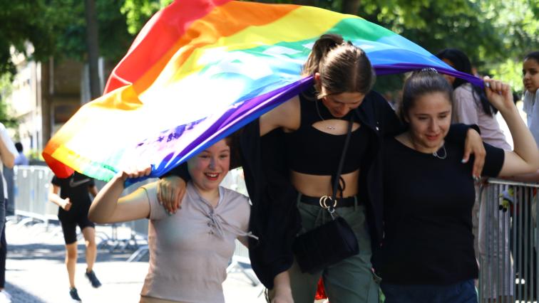 Mädchen von der weiterführenden Schule halten eine Regenbogenflagge