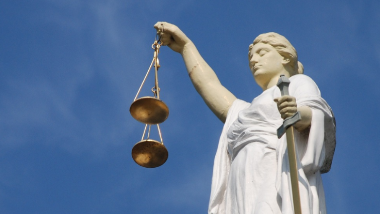 Eine Justitia-Statue vor einem blauen Himmel