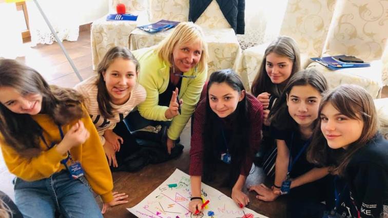 Peaceful Schools: Jugendliche malen auf ein Plakat