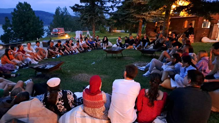 People sitting in a circle around a fire place