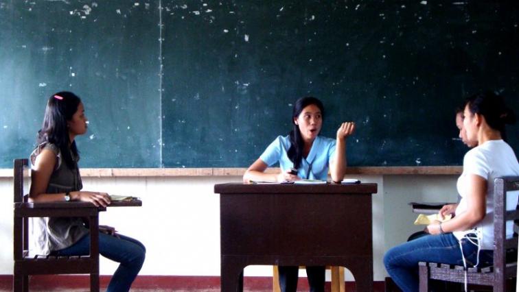 Three students discussing in a classroom