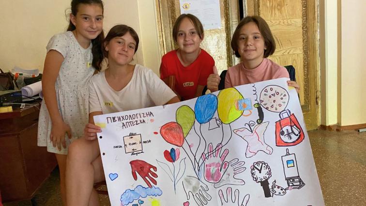 Kinder in der Ukraine halten ein von ihnen gestaltetes Plakat hoch