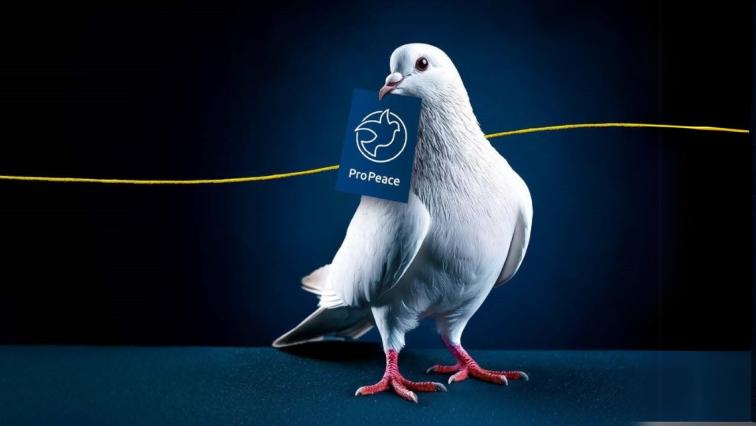 Eine Taube trägt das neue Pro Peace Logo im Schnabel.