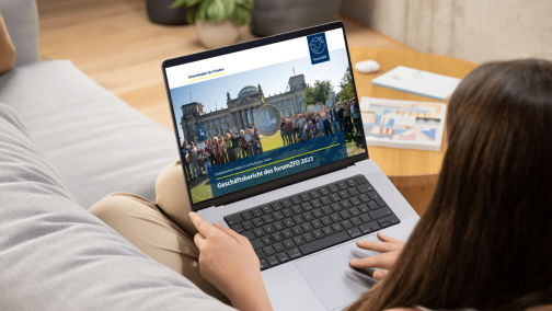 Eine Frau liest den Pro Peace Gesch&auml;ftsbericht 2023 auf ihrem Laptop